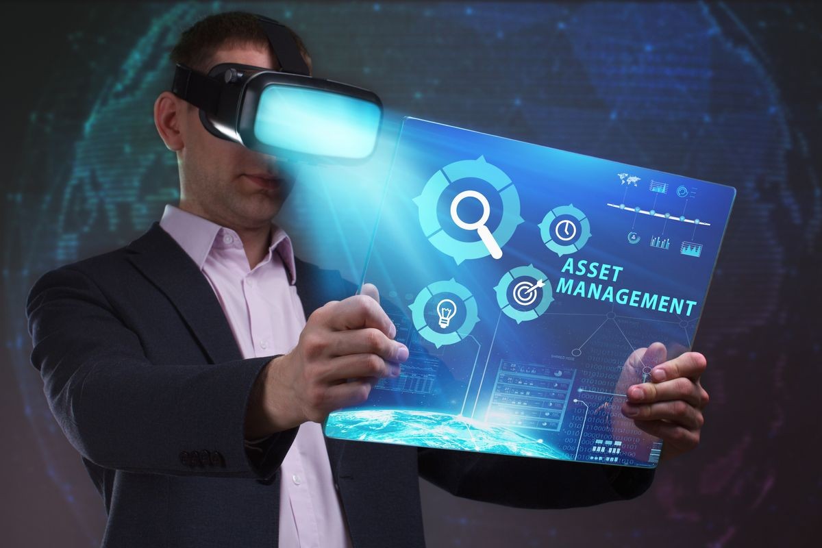 Business, Technology, Internet and network concept. Young businessman working in virtual reality glasses sees the inscription: Asset management