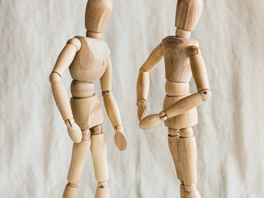 Dos figuras de madera, una frente a otra.
